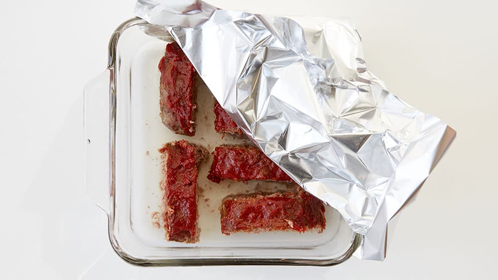 Slice the meatloaf and place in a baking dish. Add a small amount of water to the dish and cover with foil.