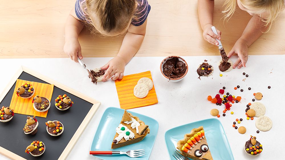 Kids decorating thanksgiving cookies and pies