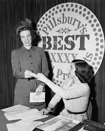 A beaming Smalfeld accepts her $50,000 grand prize check at the inaugural Bake-Off® Contest in 1949.