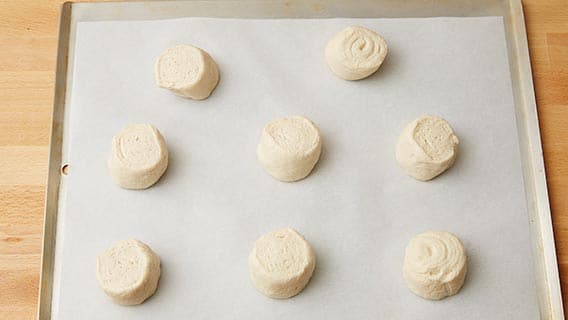 Circles of bread dough on a parchment-lined cookie sheet