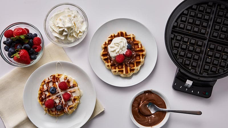Waffle iron, waffle, nutella, berries, whipping cream.