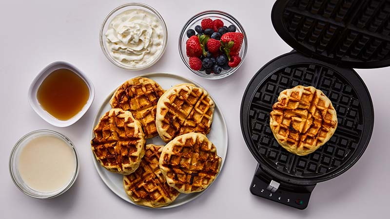 Waffle iron, waffles, syrup, berries, cream cheese glaze, whipped cream.