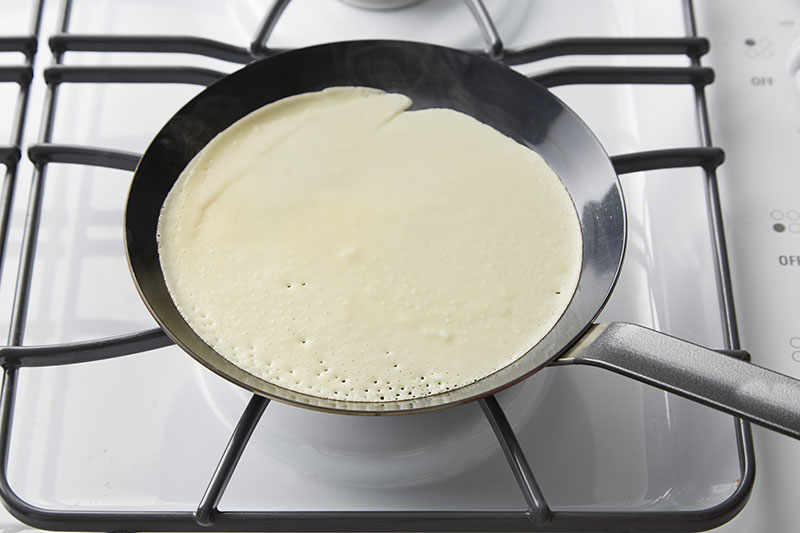 Pour ¼ cup of the thin batter into the hot pan.