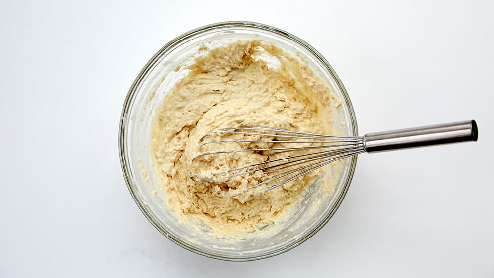 Pancake batter in a mixing bowl, with a whisk