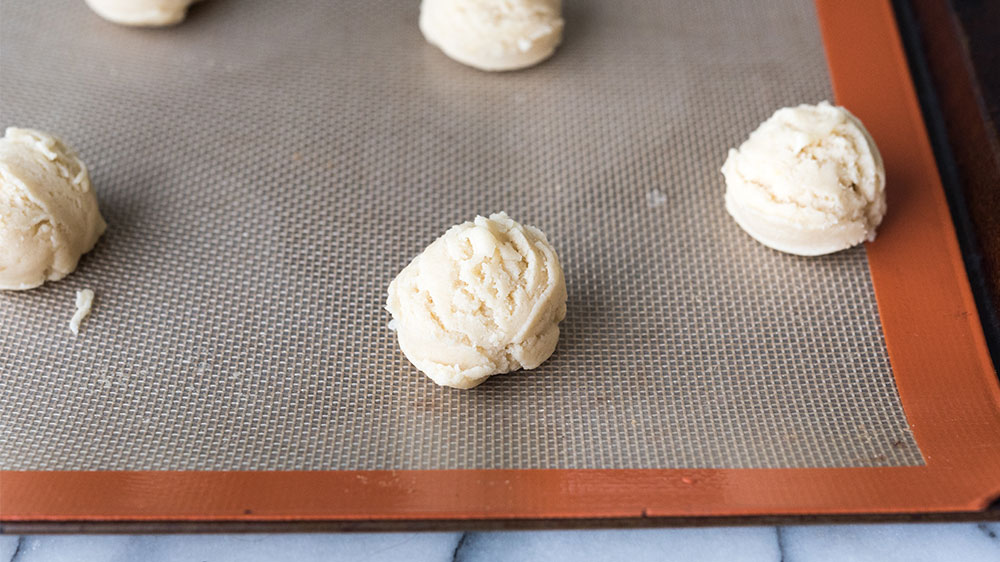 Rounded spoonfuls of cookie dough on baking sheet