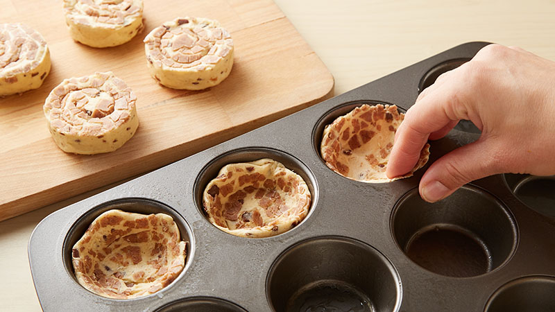 Press cinnamon rolls into muffin cups