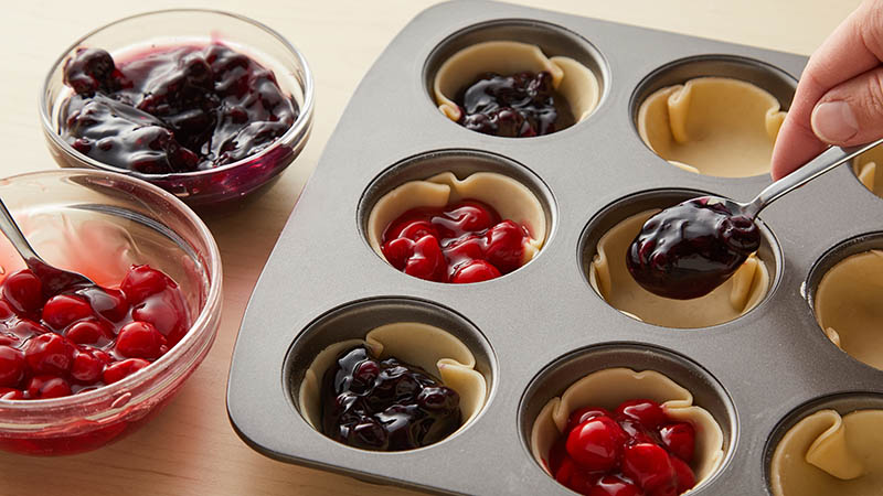 Fill muffin cups with cherry or blueberry filling