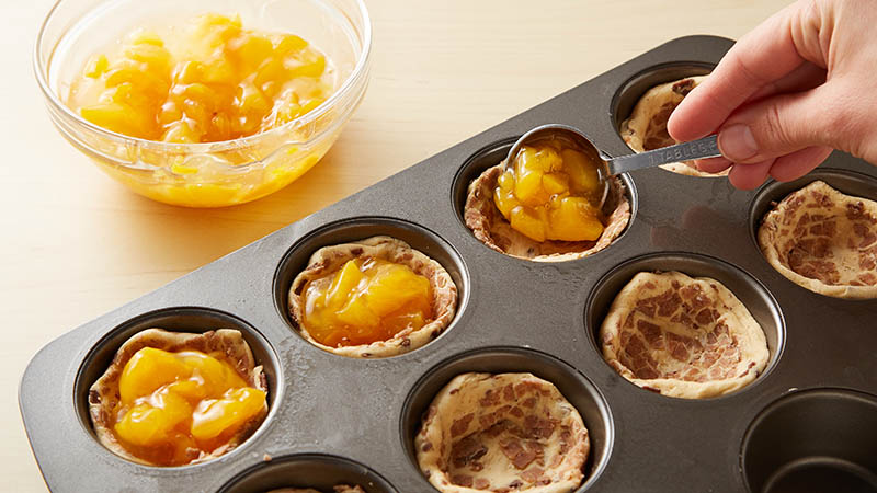 Fill pie cups with peaches