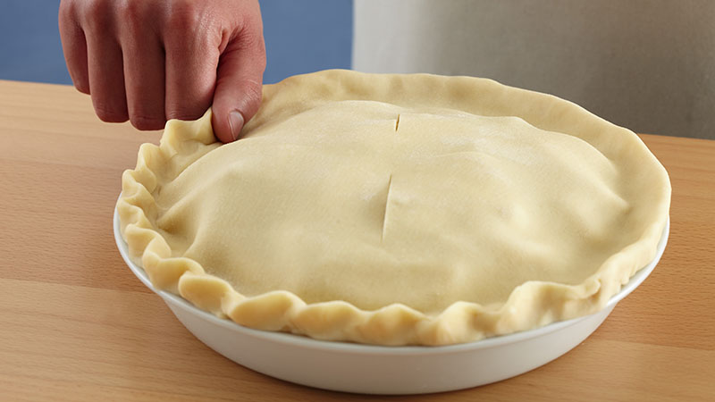 Place the side of your thumb on the pastry edge at an angle. Pinch the pastry by pressing the knuckle of your index finger down into the pastry toward your thumb.