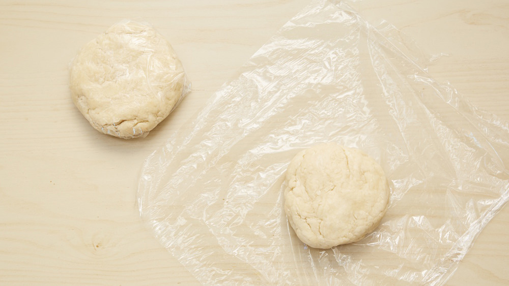 Shape the dough into two equal-sized balls and flatten them slightly to make small discs. Wrap each in some plastic wrap and place in the refrigerator for about 30 minutes. 