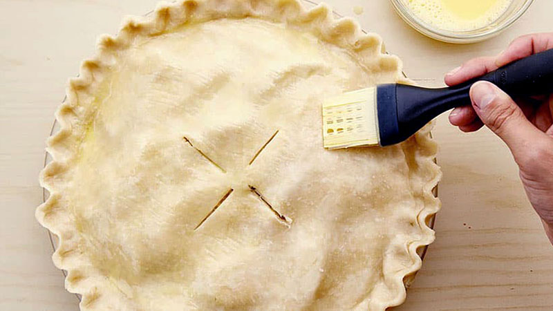 Brushing pie crust with egg wash