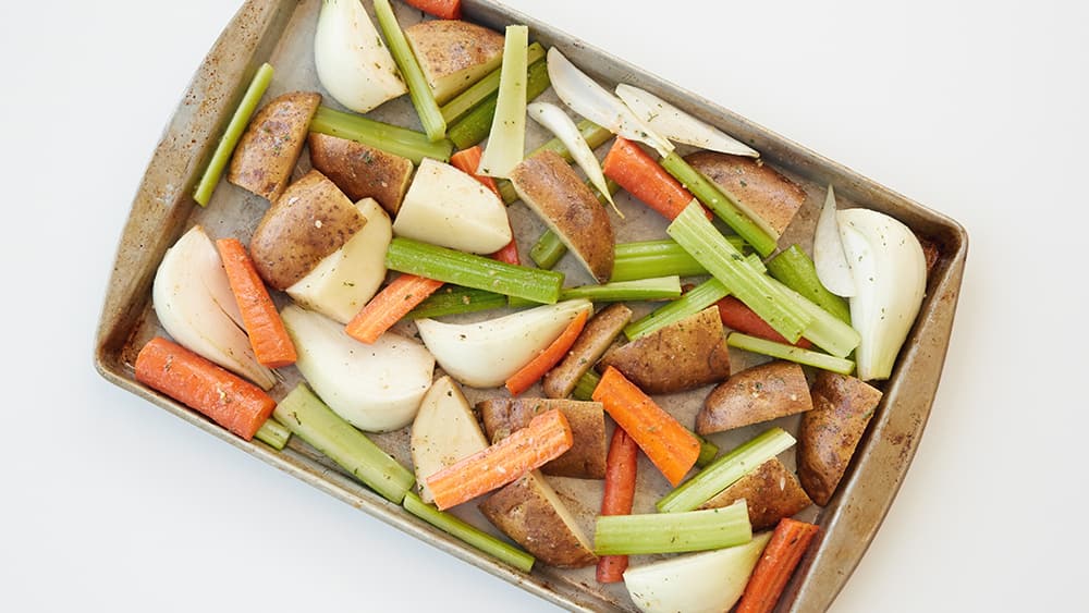 Celery, carrots, potatoes on a baking sheet
