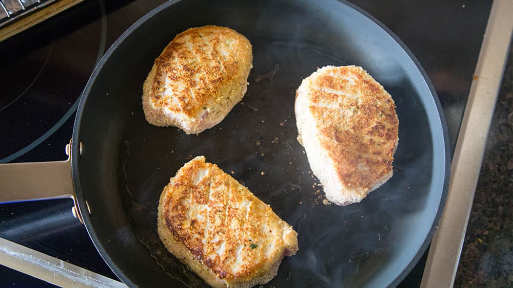 Brown coated pork chops in a skillet