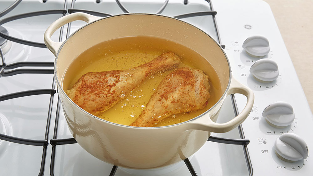 Turkey legs in a pan of oil on the stove top