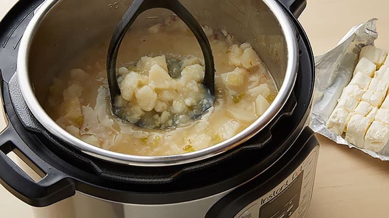 Open the pot and mash the potatoes.