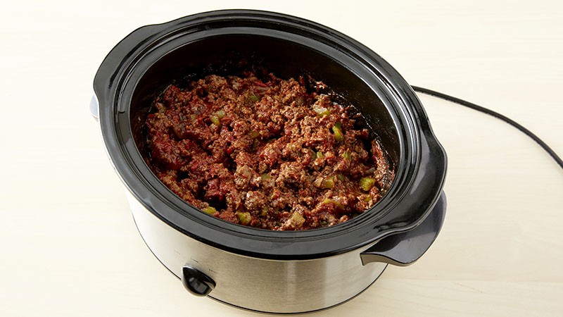 Combine the ground beef mixture and remaining ingredients in a slow cooker.