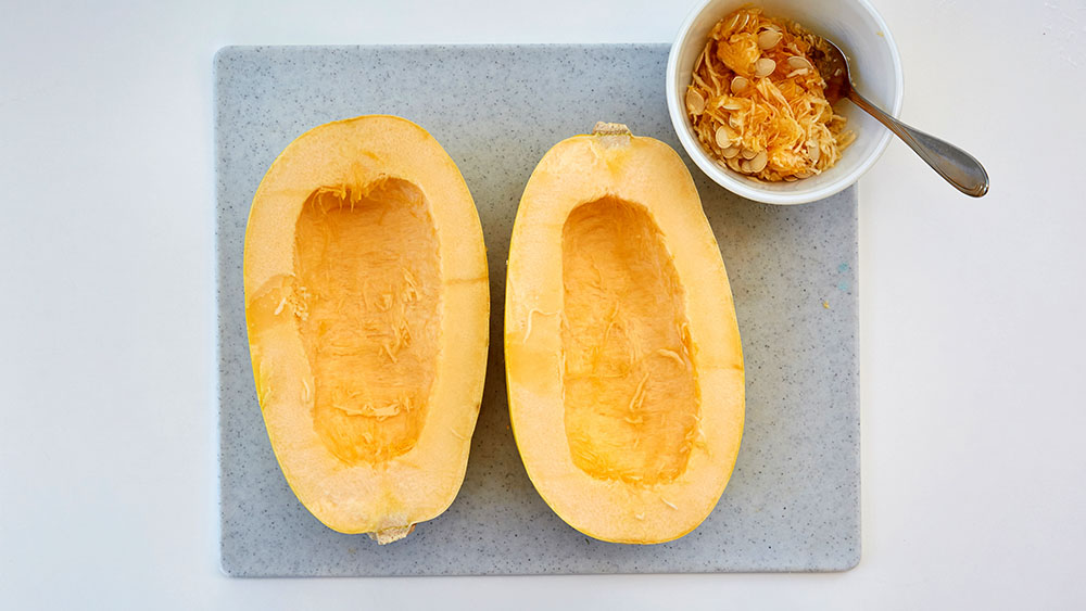 Cut the spaghetti squash lengthwise. Scoop and discard the seeds.