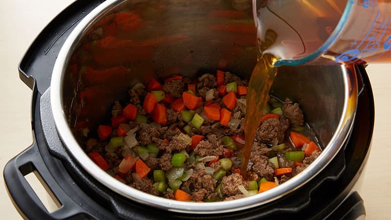 Pour the broth into the beef mixture.