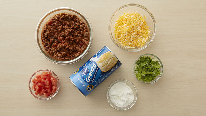 ground beef, shredded cheese, shredded lettuce, sour cream, pillsbury grands biscuits, tomatoes