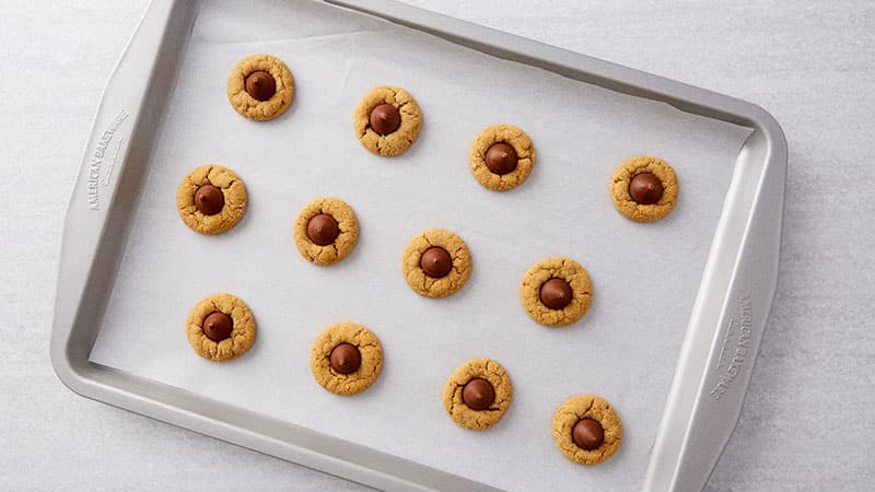 Peanut Blossoms on a baking sheet lined with parchment paper