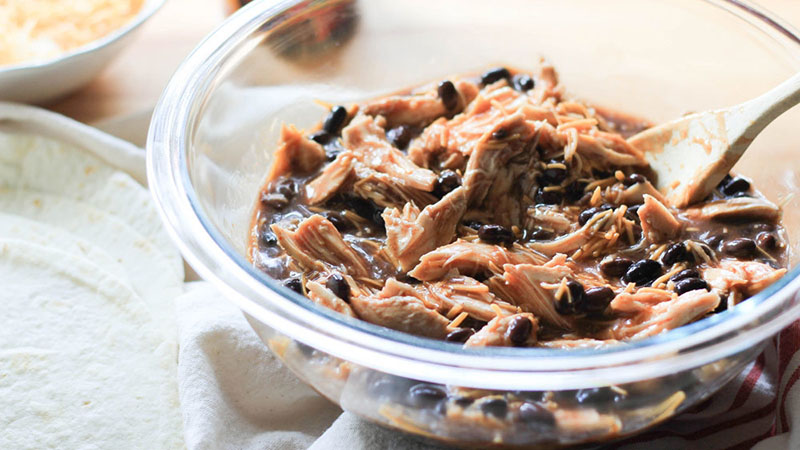 Combine shredded chicken, enchilada sauce, black beans and shredded cheese in a large bowl.
