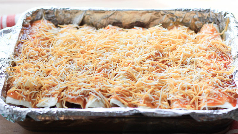 Put enchilada sauce and shredded cheese over the enchiladas.