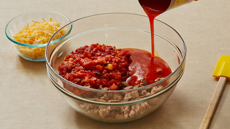Combine browned ground beef, enchilada sauce, salsa, and shredded cheese in a large bowl.