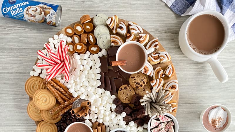Hot Chocolate Charcuterie Board - marshmallows, cookies, cinnamon sticks, pillsbury cinnamon rolls, cup of hot chocolate, peppermint sticks