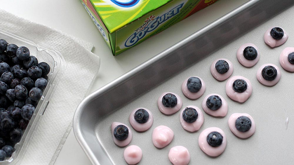 Drops of Go-Gurt topped with a blueberry on a baking sheet