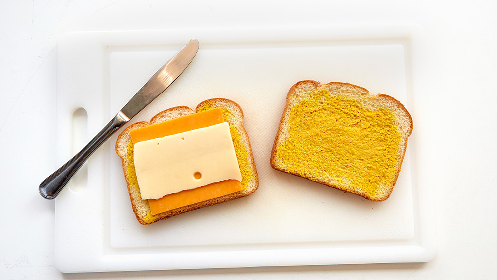 Spread one side of each slice of bread with mustard. Top one slice with your Cheddar and Swiss cheese slices. 