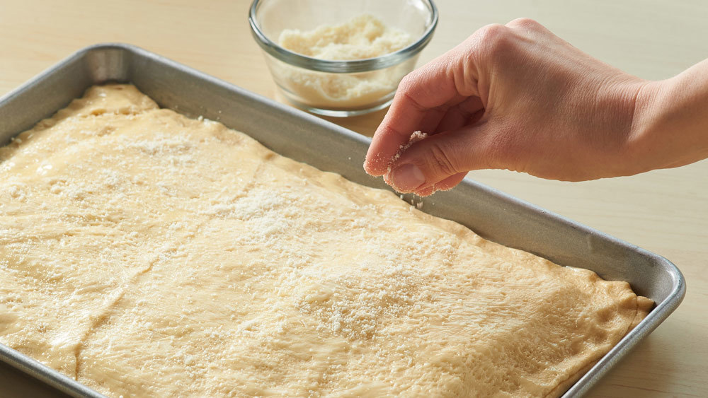 Unroll the second can of dough and stretch it over the filling. 