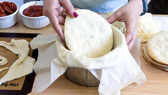 Placing circle of dough in round cake pan