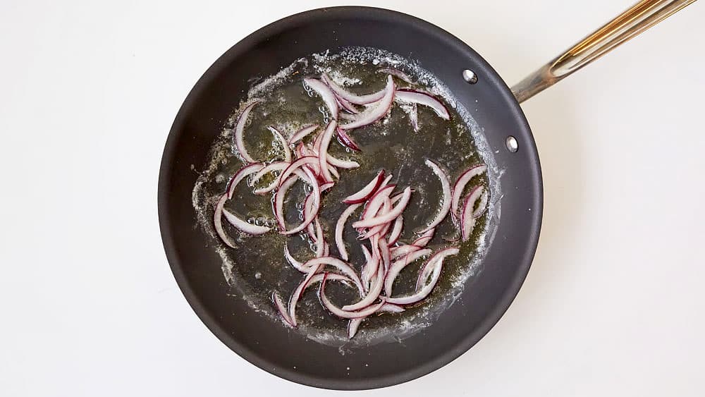 Cook thinly sliced red onion in butter, stirring occasionally. 