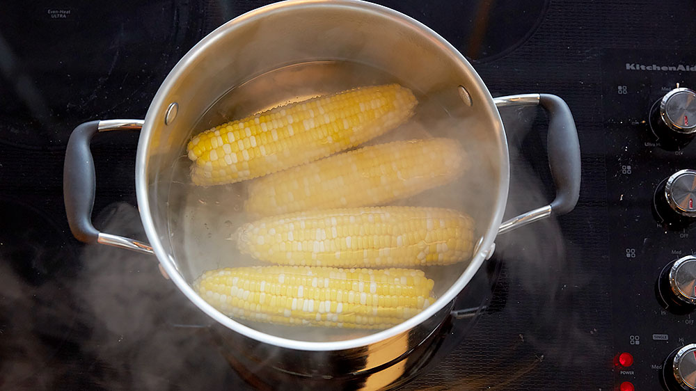 Boiling ears of corn.