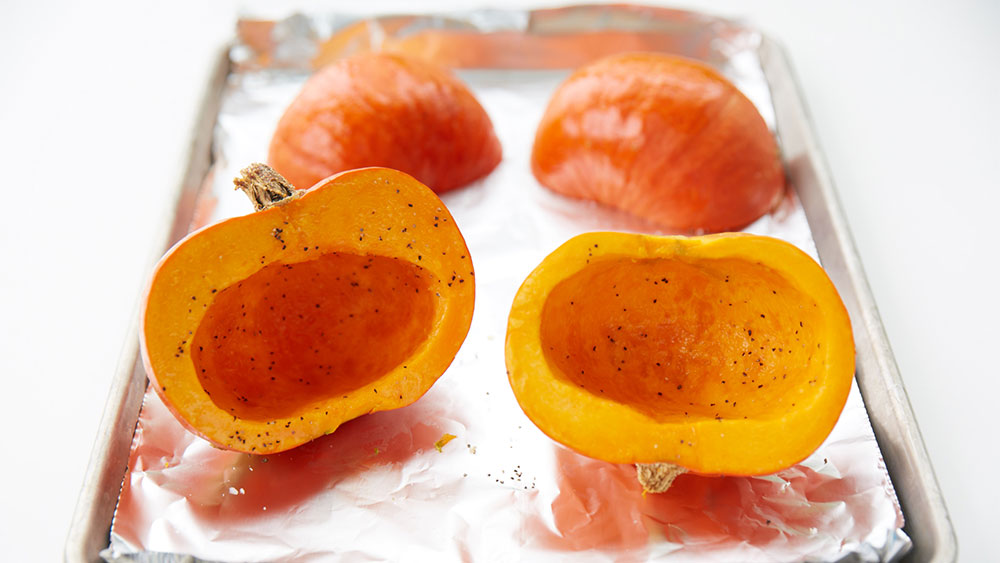 Pumpkins, cut in half, on a baking sheet