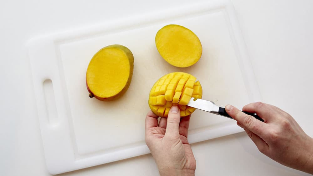 Push skin inside-out so cut mango pieces fan out, and cut pieces from skin.