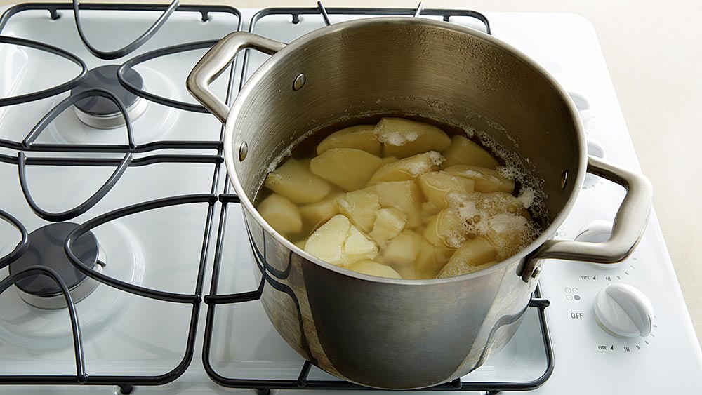 Peeled, cubed potatoes in a pan of water on the stove