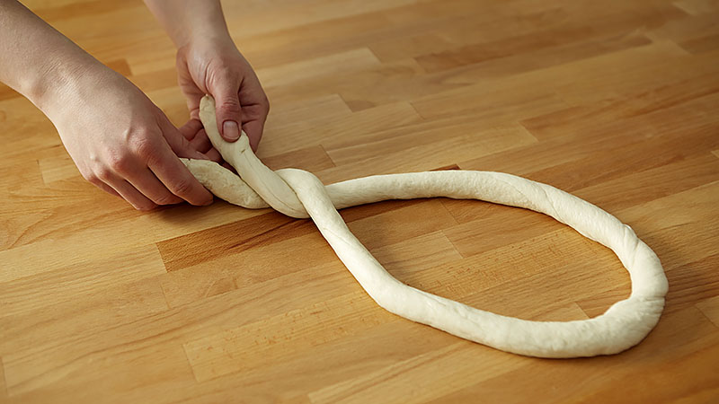 Form dough into U shape. Twist ends together twice. 