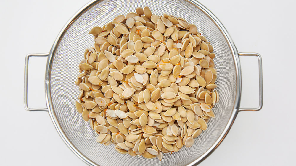 Raw pumpkin seeds in a colander