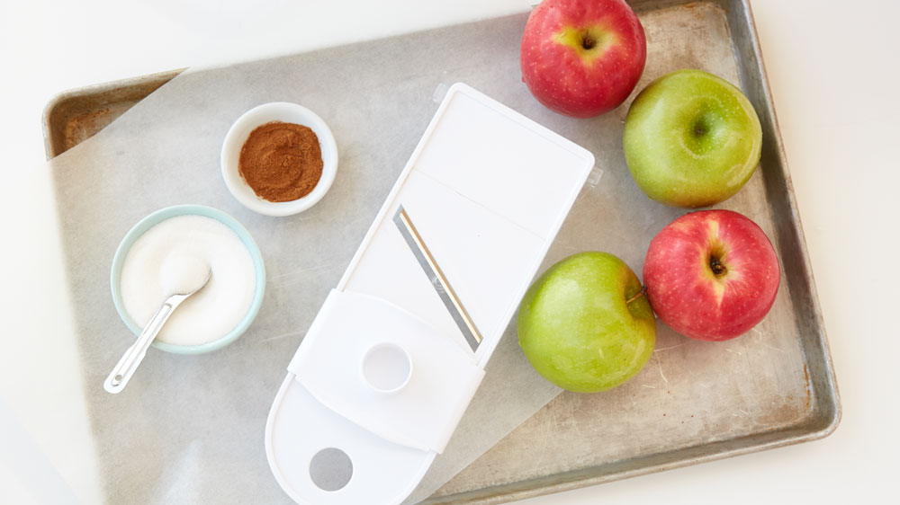 Apples, mandolin, cinnamon, sugar on a parchment paper lined baking sheet