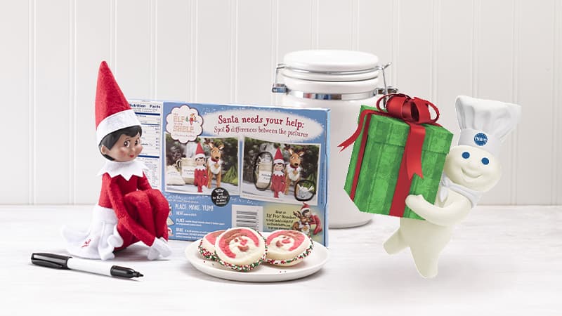 Elf on the Shelf with cookies and the Pillsbury Doughboy with a present