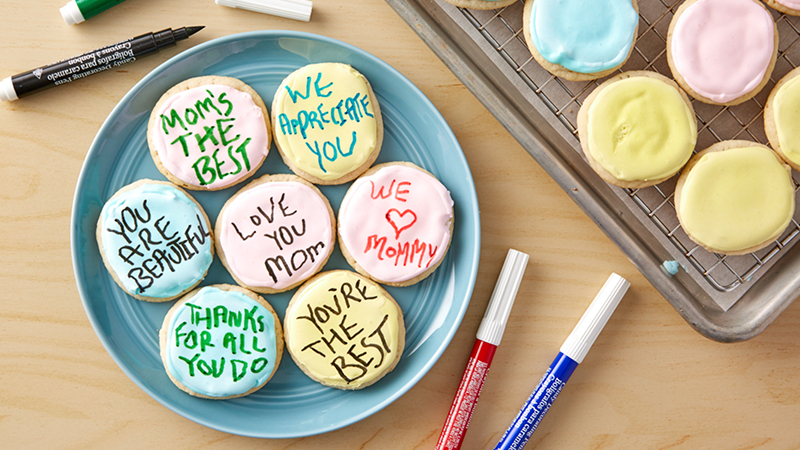 Frosted cookies with messages on them, colored markers