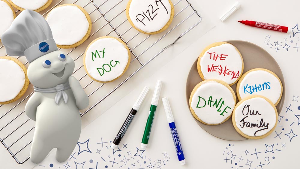 Frosted sugar cookies with writing on them; The Pillsbury Doughboy