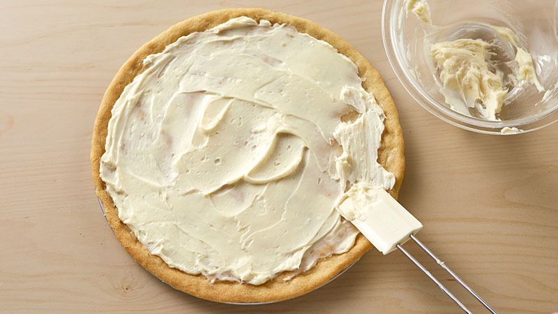 Spread the frosting evenly over the cooled crust.