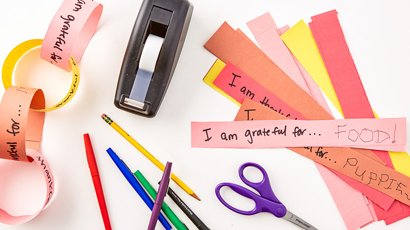 Tape dispenser, scissors, pens and pencils, strips of construction paper