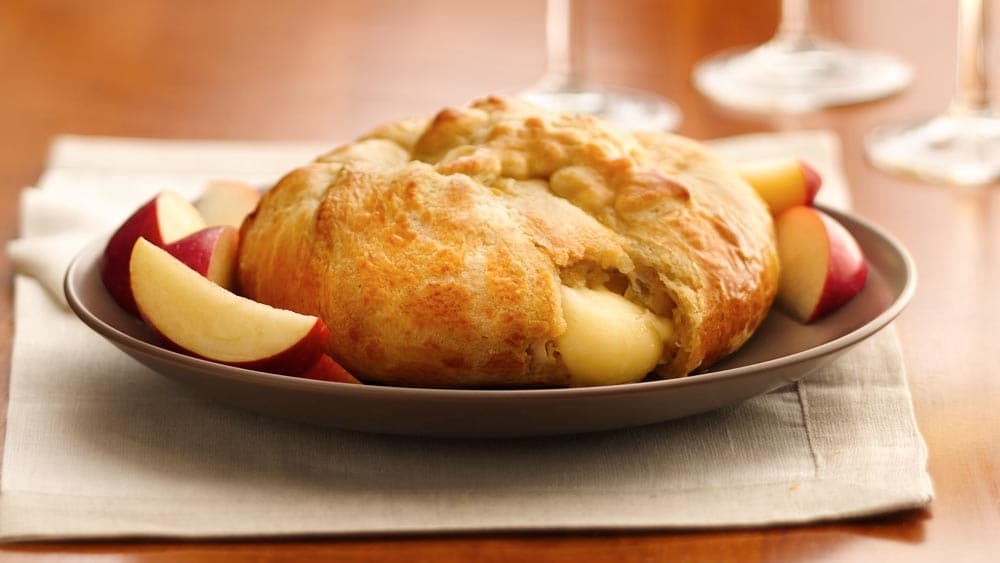 a plate with a crescent-wrapped brie and slices of apple